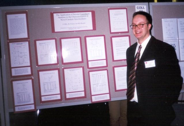 Patrick Mills standing in front of poster at ACS
