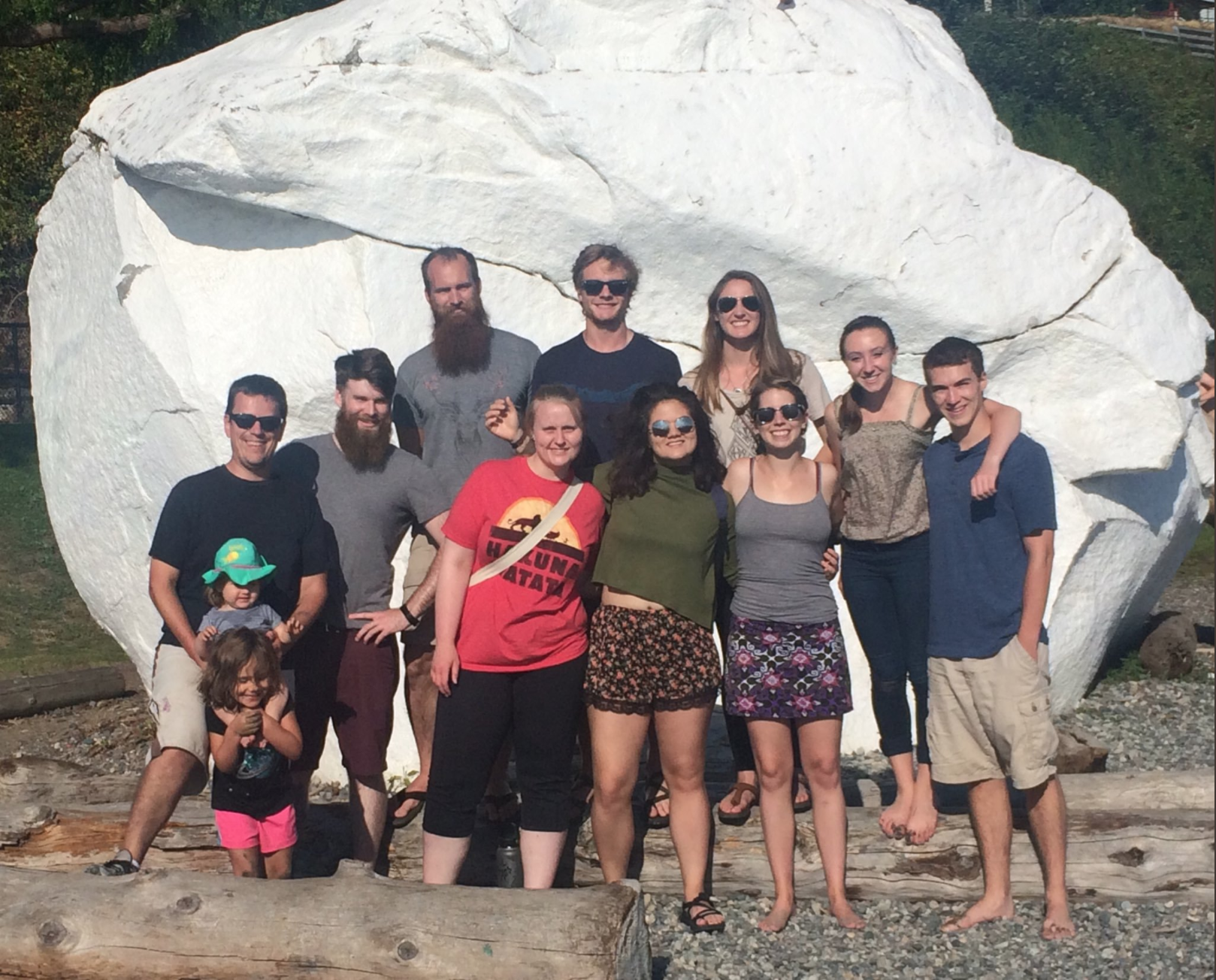 Students pose in front of a giant, white boulder