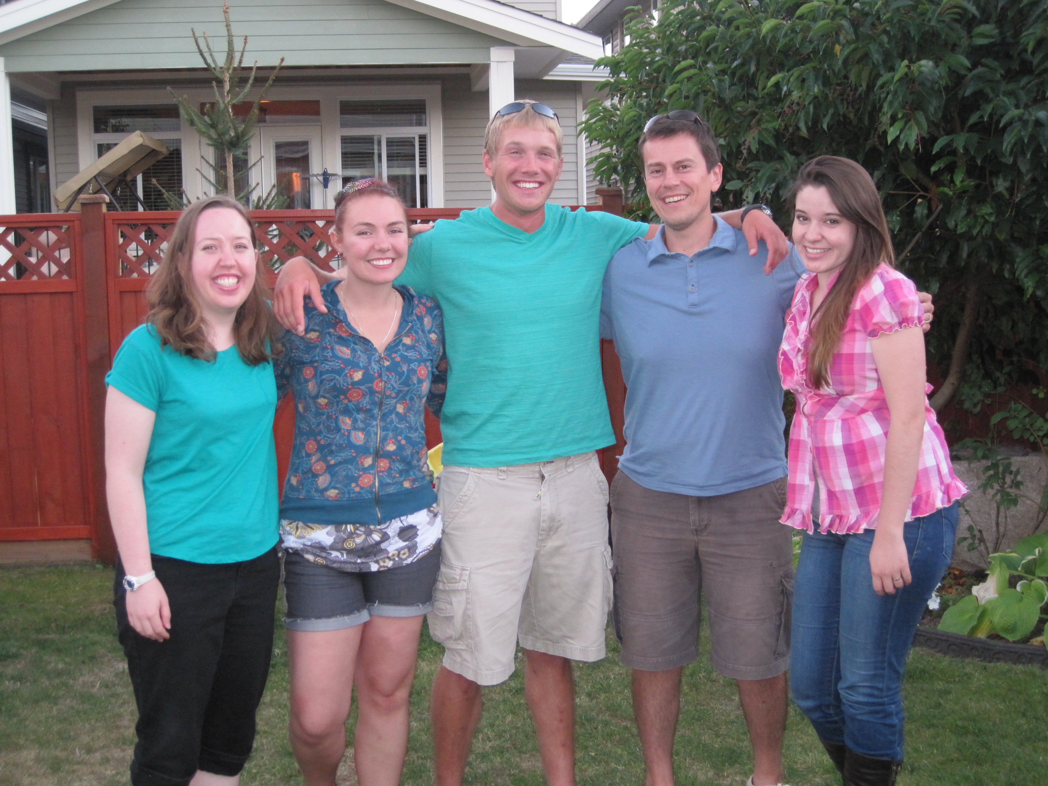A group of students pose on a grass lawn at the Rider Group BBQ in summer 2014