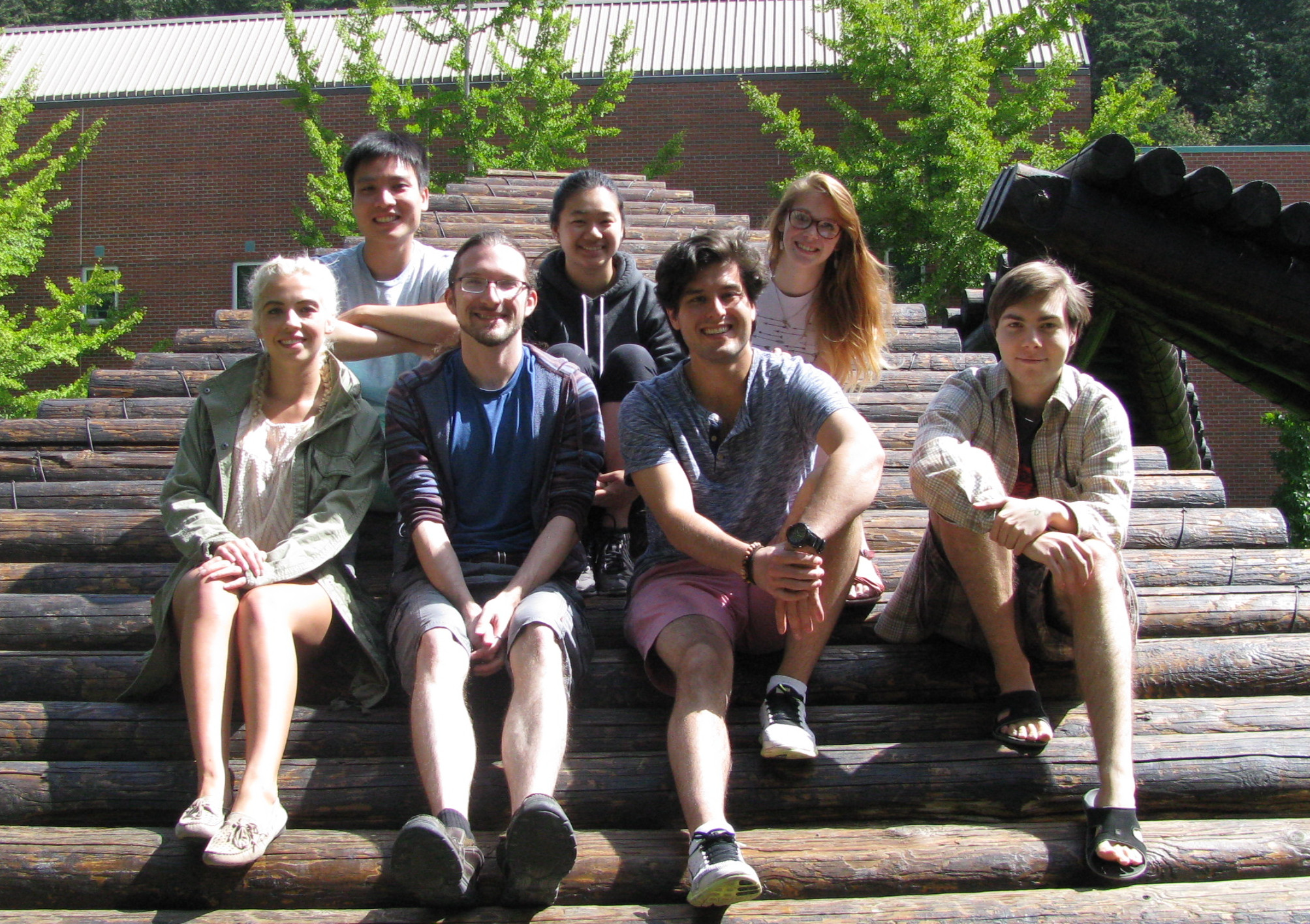 a group of students poses on a wooden sculpture Summer 2016