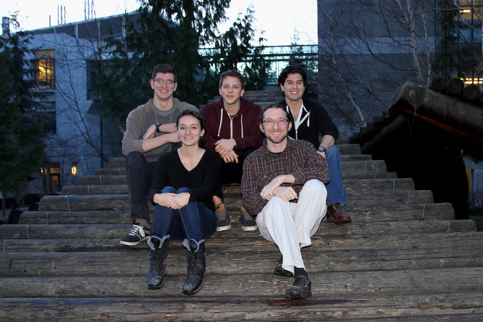 A small group of students poses on a wooden sculpture Winter 2015
