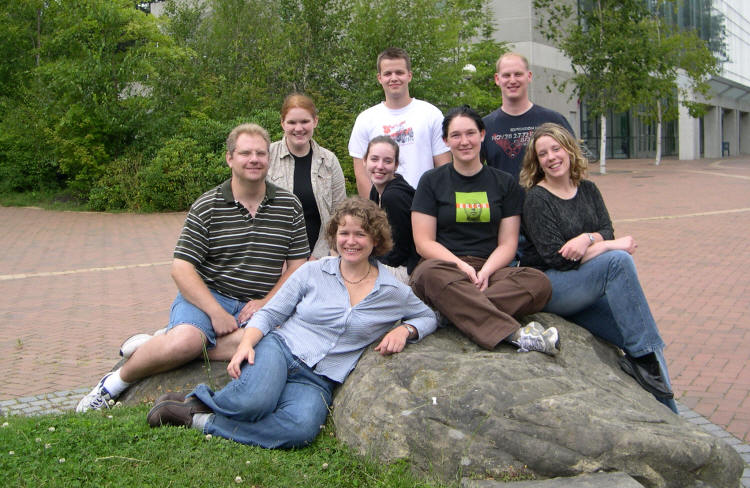 Group of students sitting on rock outside chemistry building