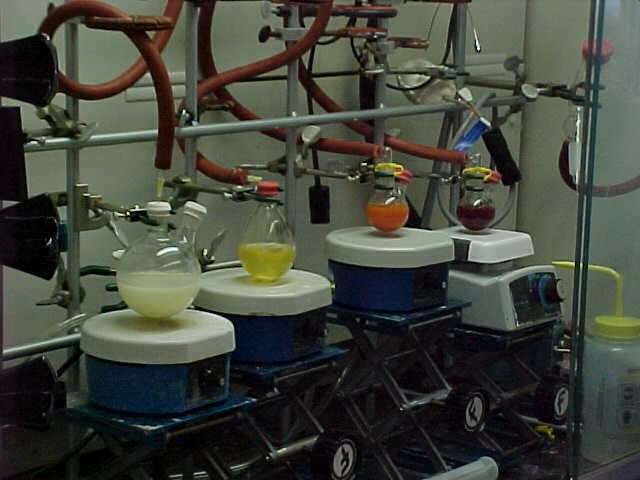 materials in beakers connected to tubing and resting on blue stands