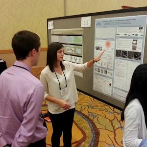 Student presenting poster while others watch